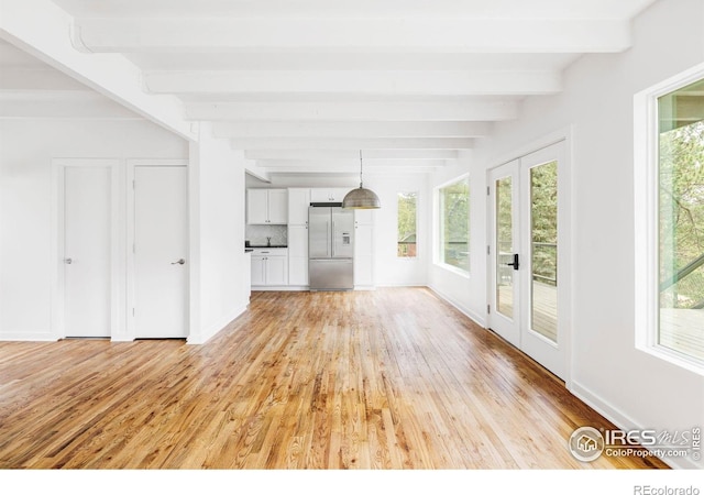 781 Cold Springs Rd, Nederland, CO 80466 - unfurnished living room featuring light wood-style flooring, healthy amount of natural light, and beamed ceiling