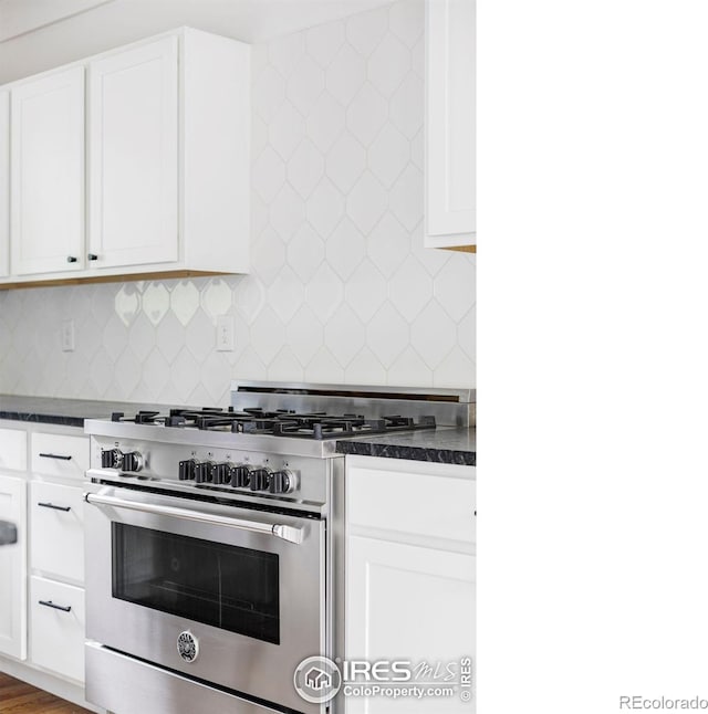 781 Cold Springs Rd, Nederland, CO 80466 - kitchen featuring gas stove, dark countertops, decorative backsplash, and white cabinets