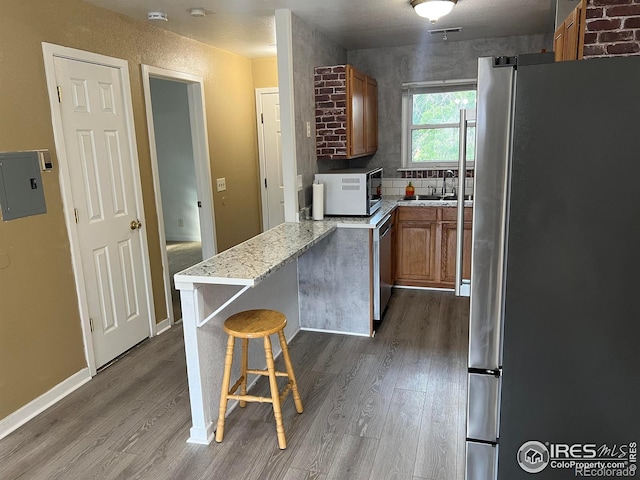 225 E 8th Ave Unit B11, Longmont, CO 80504 - kitchen featuring appliances with stainless steel finishes, brown cabinets, and wood finished floors