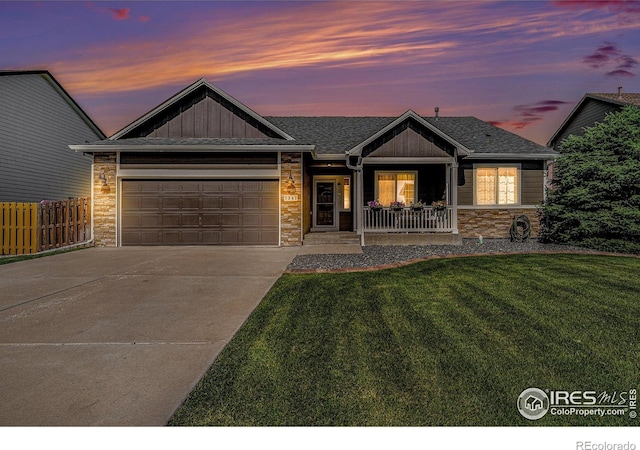 7347 Ocean Ridge St, Wellington, CO 80549 - view of front of house featuring concrete driveway, an attached garage, covered porch, roof with shingles, and board and batten siding