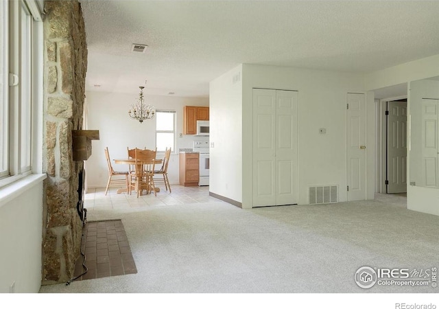 3345 Chisholm Trl Unit 206, Boulder, CO 80301 - living room with a chandelier, light colored carpet, and a textured ceiling