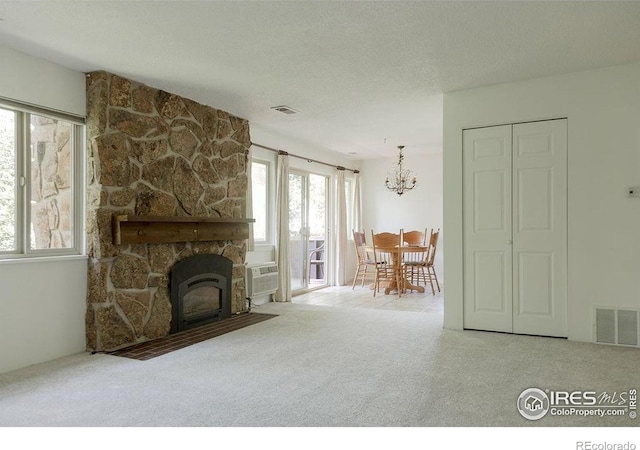 3345 Chisholm Trl Unit 206, Boulder, CO 80301 - living area with carpet, a chandelier, a wall mounted air conditioner, and a textured ceiling