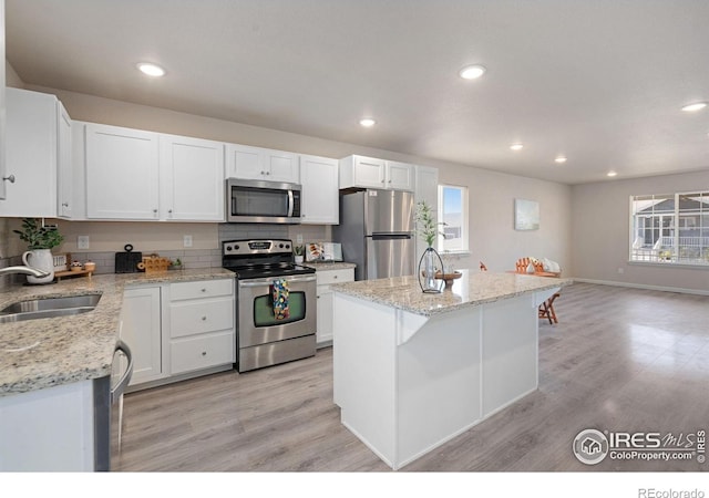 4216 Yellowbells Dr, Evans, CO 80620 - kitchen featuring appliances with stainless steel finishes, light wood-type flooring, recessed lighting, and white cabinets