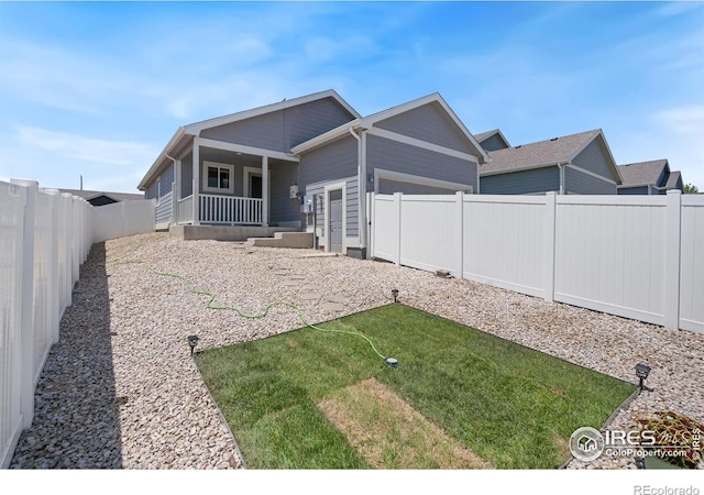 4216 Yellowbells Dr, Evans, CO 80620 - rear view of house with a fenced backyard, covered porch, and an attached garage