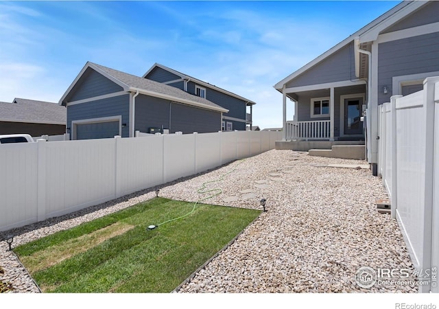 4216 Yellowbells Dr, Evans, CO 80620 - fenced backyard featuring an attached garage and covered porch