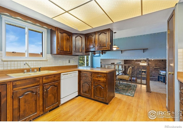 610 S Broadway Ave, Fort Lupton, CO 80621 - kitchen featuring dishwasher, light wood-style flooring, decorative backsplash, and a peninsula