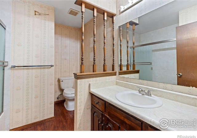 610 S Broadway Ave, Fort Lupton, CO 80621 - bathroom featuring wood finished floors, vanity, and a shower with door