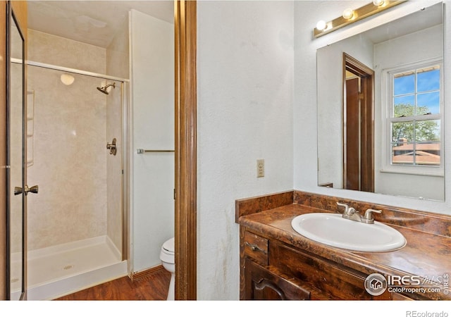 610 S Broadway Ave, Fort Lupton, CO 80621 - full bath featuring vanity, a shower stall, and wood finished floors