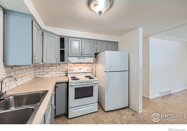 131 E 15th Ave, Longmont, CO 80504 - kitchen with white appliances, under cabinet range hood, tasteful backsplash, light countertops, and gray cabinetry