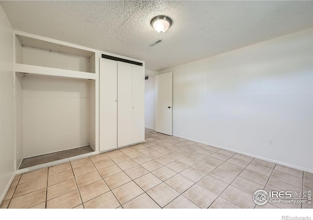 131 E 15th Ave, Longmont, CO 80504 - unfurnished bedroom with a closet, a textured ceiling, and light tile patterned floors