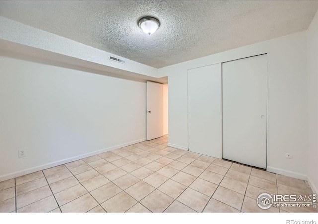 131 E 15th Ave, Longmont, CO 80504 - unfurnished bedroom with a closet, a textured ceiling, and light tile patterned flooring