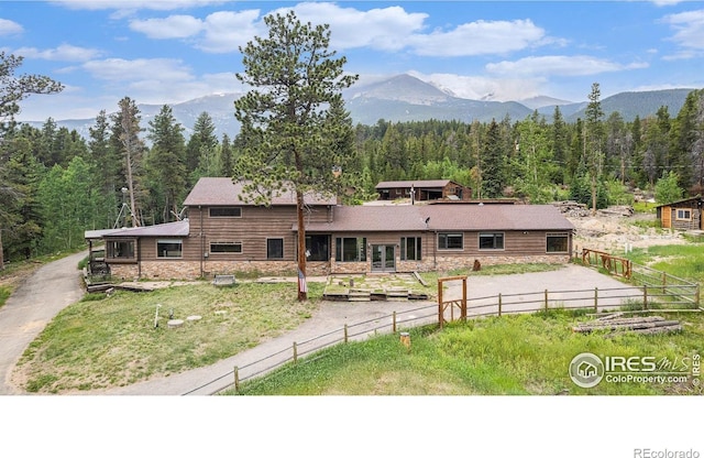 8451 Peak To Peak Hwy, Allenspark, CO 80510 - view of front of property featuring a forest view, stone siding, a mountain view, and driveway