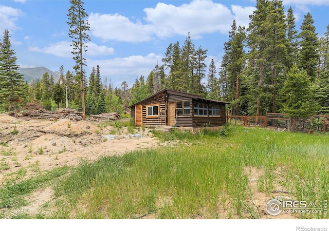 8451 Peak To Peak Hwy, Allenspark, CO 80510 - view of front of home with faux log siding, a mountain view, and a forest view