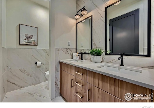 1109 Neon Forest Cir # 2, Longmont, CO 80504 - full bath with tile walls, marble tiled floors, double vanity, and wainscoting