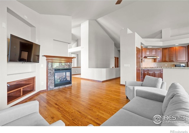 1513 Cannon Mountain Dr, Longmont, CO 80503 - living area featuring a tiled fireplace, high vaulted ceiling, and light wood finished floors