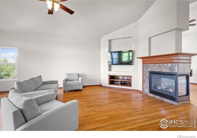 1513 Cannon Mountain Dr, Longmont, CO 80503 - living room with a ceiling fan, vaulted ceiling, wood finished floors, and a premium fireplace
