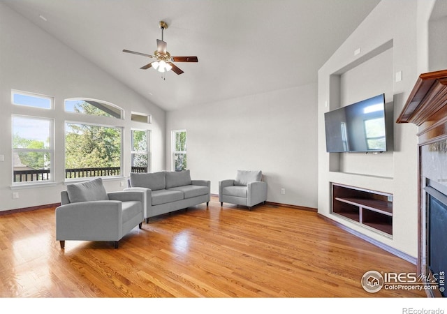 1513 Cannon Mountain Dr, Longmont, CO 80503 - living room featuring a glass covered fireplace, a ceiling fan, light wood-type flooring, and high vaulted ceiling
