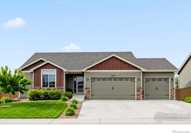 3454 Buffalo Grass Ln, Wellington, CO 80549 - view of front of house featuring an attached garage, driveway, a shingled roof, and stone siding