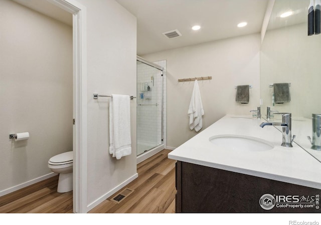 3775 Ginkgo St, Wellington, CO 80549 - bathroom with wood finished floors, a shower stall, double vanity, and recessed lighting