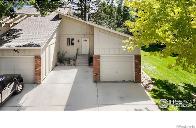 3012 Anchor Way Unit 3, Fort Collins, CO 80525 - view of front facade with brick siding, roof with shingles, board and batten siding, and a garage