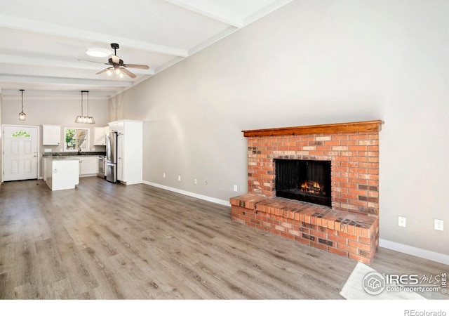 3012 Anchor Way Unit 3, Fort Collins, CO 80525 - unfurnished living room featuring ceiling fan, beam ceiling, a fireplace, and wood finished floors
