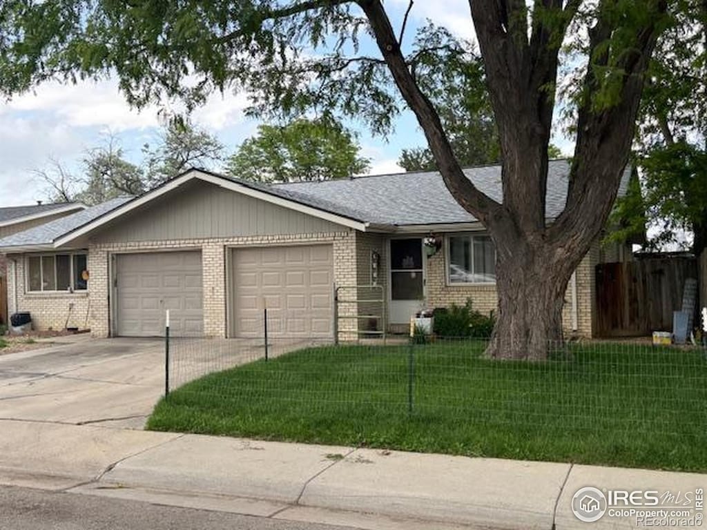 1906 Yeager Dr, Longmont, CO 80501 - ranch-style home with an attached garage, brick siding, concrete driveway, and roof with shingles