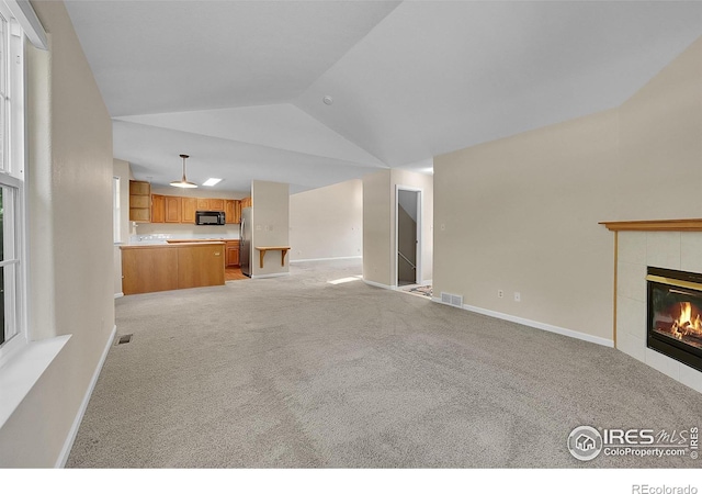 3132 Concord Way, Longmont, CO 80503 - unfurnished living room featuring a fireplace, high vaulted ceiling, and light colored carpet