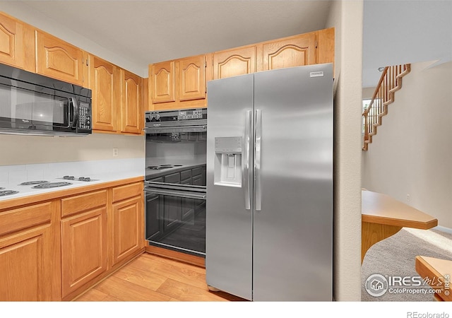 3132 Concord Way, Longmont, CO 80503 - kitchen with black appliances, light wood-style floors, light countertops, and light brown cabinetry