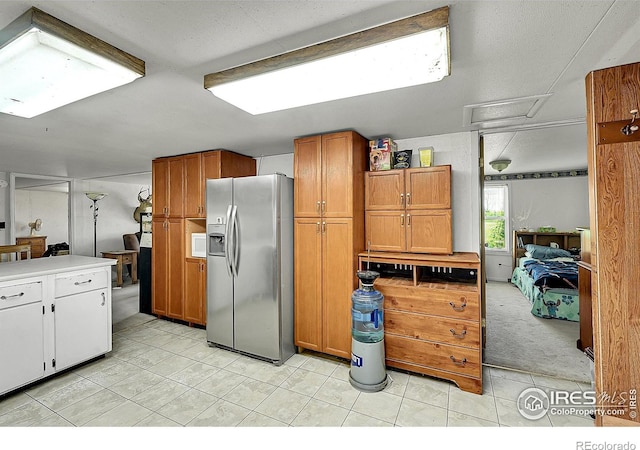 18247 County Road 22, Fort Lupton, CO 80621 - kitchen with stainless steel fridge with ice dispenser, light tile patterned floors, brown cabinetry, and light countertops