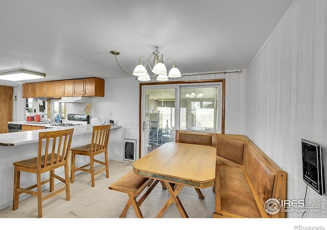 18247 County Road 22, Fort Lupton, CO 80621 - dining area featuring a chandelier, light carpet, and wooden walls