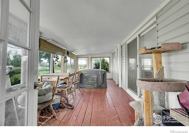 18247 County Road 22, Fort Lupton, CO 80621 - sunroom featuring a hot tub, a textured ceiling, hardwood / wood-style flooring, and a wooden deck