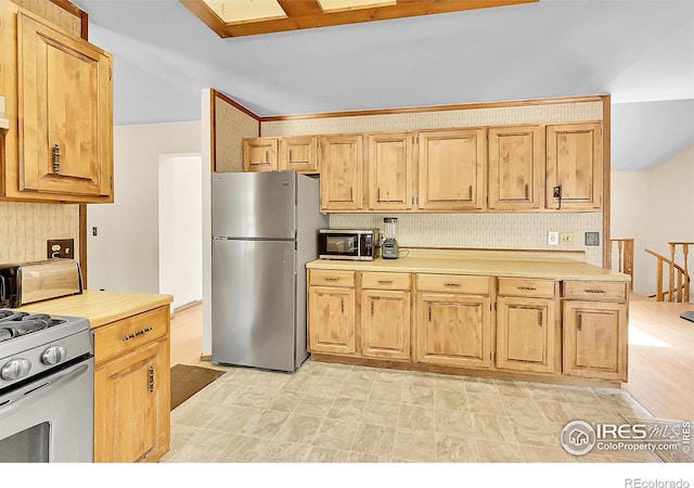 56 Bounty Hunter Ln, Bailey, CO 80421 - kitchen with appliances with stainless steel finishes, light countertops, light brown cabinetry, and backsplash