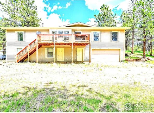 56 Bounty Hunter Ln, Bailey, CO 80421 - back of property featuring a garage, a wooden deck, and stairs