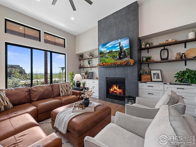 1255 Eliza Ave, Berthoud, CO 80513 - living room with light wood-style floors, a towering ceiling, ceiling fan, a fireplace, and recessed lighting
