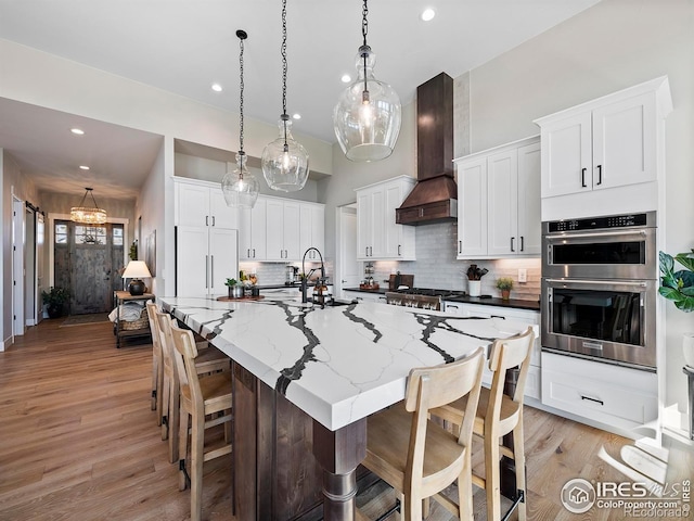 1255 Eliza Ave, Berthoud, CO 80513 - kitchen featuring premium range hood, stainless steel appliances, decorative backsplash, recessed lighting, and white cabinets