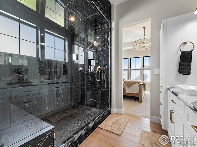1255 Eliza Ave, Berthoud, CO 80513 - ensuite bathroom with wood finished floors, a marble finish shower, vanity, and a chandelier