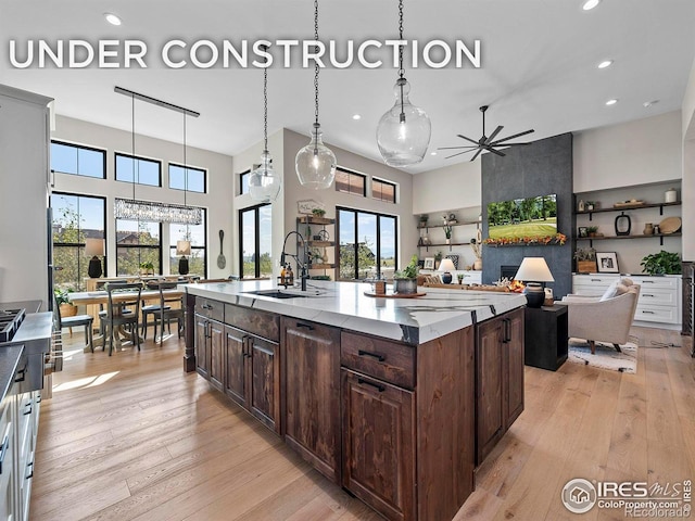 1255 Eliza Ave, Berthoud, CO 80513 - kitchen with a high ceiling, light wood-style floors, a ceiling fan, dark brown cabinetry, and recessed lighting
