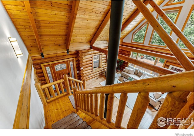 178 Hazelwood Dr, Nederland, CO 80466 - stairs with log walls, hardwood / wood-style floors, a wooden ceiling with exposed beams, and high vaulted ceiling