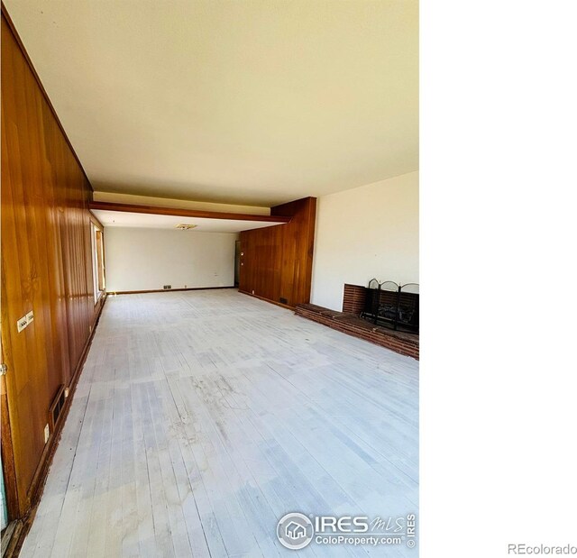 151 W 1st St N, Cheyenne Wells, CO 80810 - unfurnished living room with wood walls and light wood-style flooring