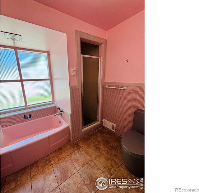 151 W 1st St N, Cheyenne Wells, CO 80810 - full bathroom featuring a garden tub, a stall shower, a wainscoted wall, and tile walls