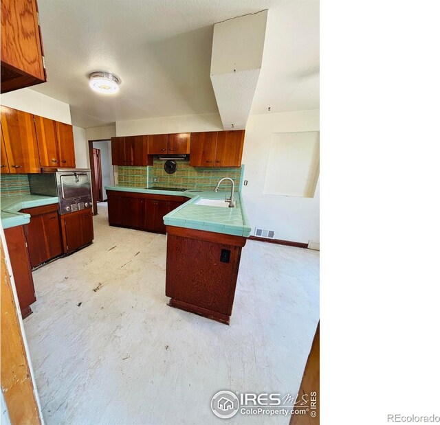 151 W 1st St N, Cheyenne Wells, CO 80810 - kitchen featuring black electric stovetop, backsplash, a peninsula, and wall oven