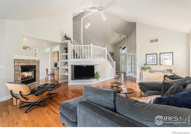 4615 Kitchell Way, Fort Collins, CO 80524 - living area with high vaulted ceiling, ceiling fan, a fireplace, wood finished floors, and stairs