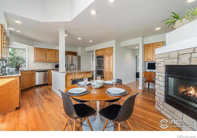 4615 Kitchell Way, Fort Collins, CO 80524 - dining space featuring light wood-type flooring, a stone fireplace, and recessed lighting