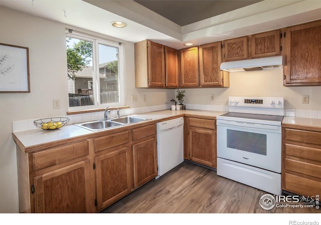 425 Walden Way, Fort Collins, CO 80526 - kitchen with white appliances, under cabinet range hood, wood finished floors, light countertops, and brown cabinets