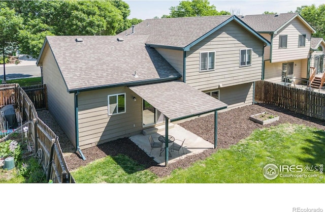 425 Walden Way, Fort Collins, CO 80526 - back of house featuring a patio, roof with shingles, a fenced backyard, and a vegetable garden