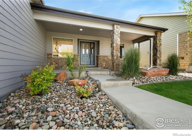 333 Braveheart Ln, Johnstown, CO 80534 - doorway to property featuring covered porch and stone siding