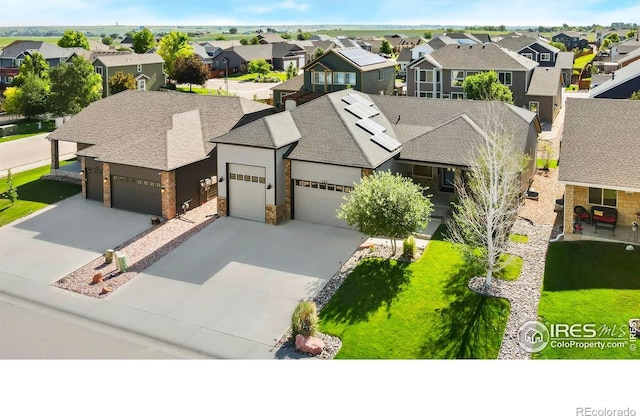 333 Braveheart Ln, Johnstown, CO 80534 - view of front of property featuring a residential view, a garage, roof with shingles, concrete driveway, and stone siding