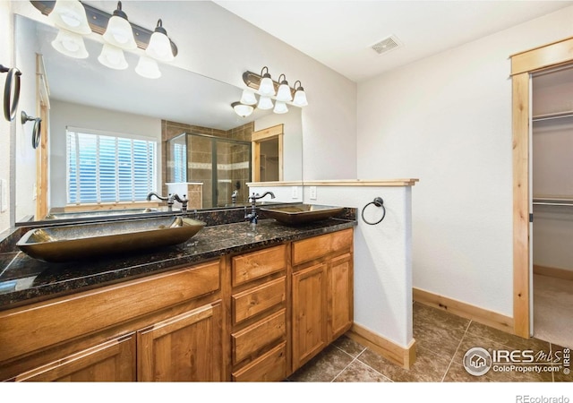 333 Braveheart Ln, Johnstown, CO 80534 - bathroom with a shower stall, double vanity, a spacious closet, and tile patterned flooring