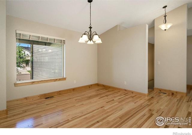 333 Braveheart Ln, Johnstown, CO 80534 - spare room featuring wood finished floors, a chandelier, and vaulted ceiling
