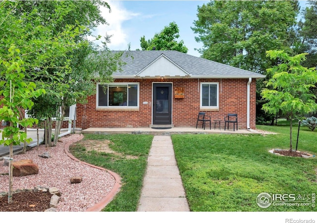 6755 W 33rd Ave, Wheat Ridge, CO 80033 - bungalow-style house with a front yard, a shingled roof, and brick siding